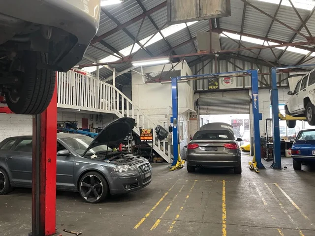 DRAUTOTEC workshop interior with vehicles on hoists